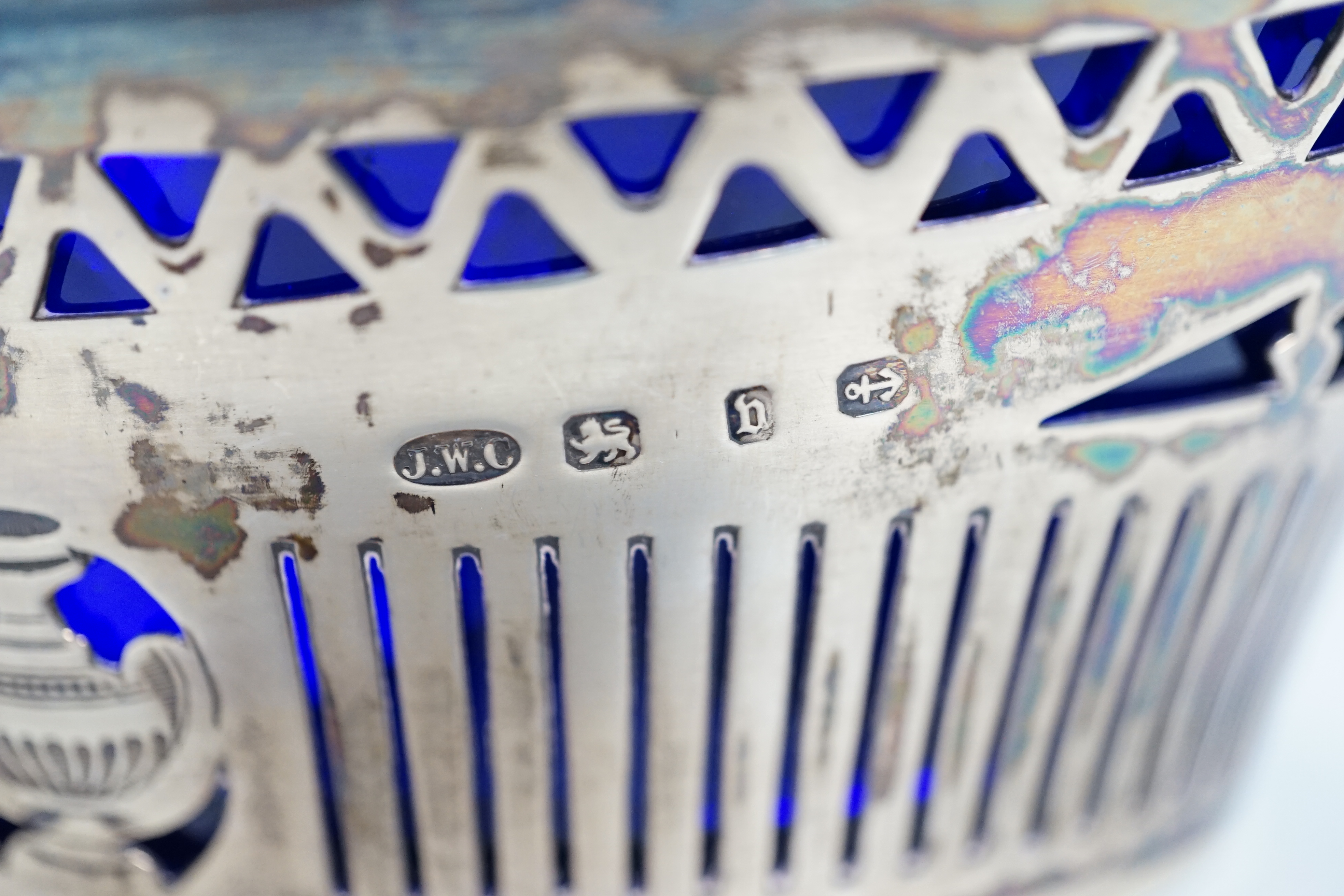 A late Victorian silver oval sugar basket, J.W. Caldicott, Birmingham, 1895, with blue glass liner, length 16.3cm.